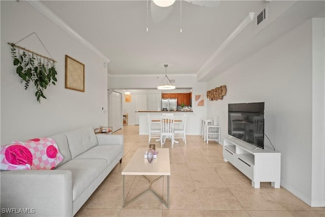 living area featuring light tile patterned floors, a ceiling fan, crown molding, visible vents, and baseboards