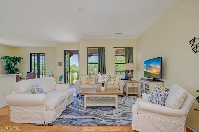 living room featuring french doors, wood finished floors, and visible vents