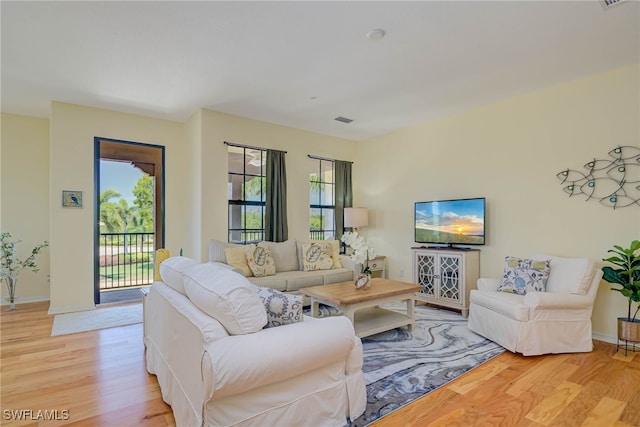 living area featuring baseboards, visible vents, and light wood-style flooring