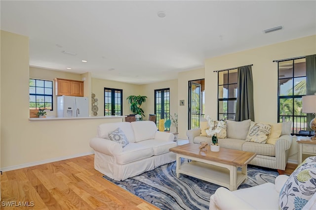 living area featuring visible vents, recessed lighting, plenty of natural light, and light wood-type flooring