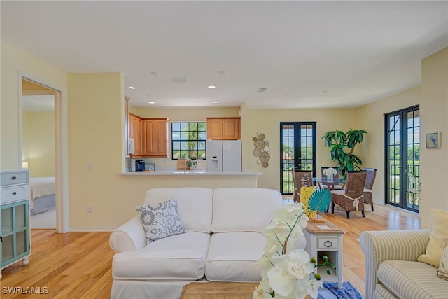 living area featuring recessed lighting, baseboards, french doors, and light wood-style floors