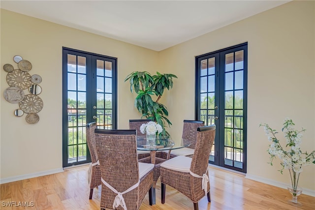 dining room with plenty of natural light, french doors, and light wood-style flooring