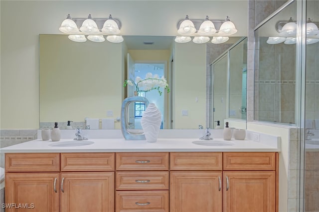 bathroom featuring a sink, a shower stall, double vanity, and visible vents
