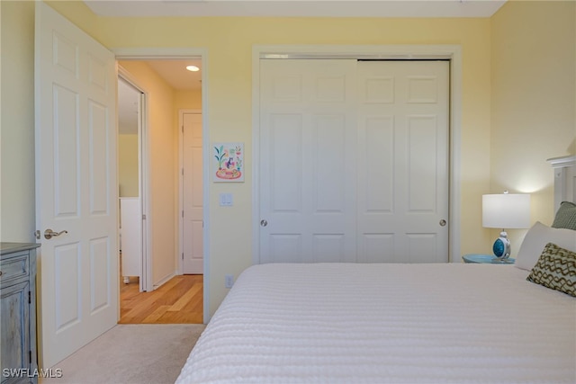 bedroom with a closet, recessed lighting, and light colored carpet