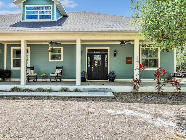 property entrance featuring covered porch, ceiling fan, and roof with shingles