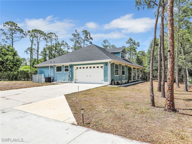 view of front of property with an attached garage, a shingled roof, cooling unit, and concrete driveway