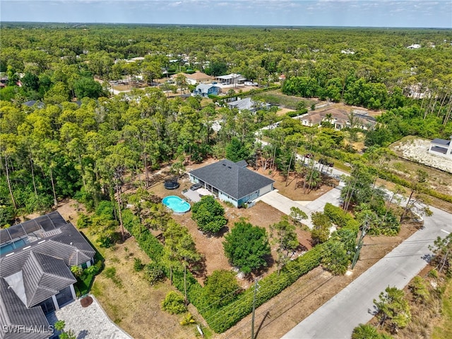 drone / aerial view featuring a wooded view