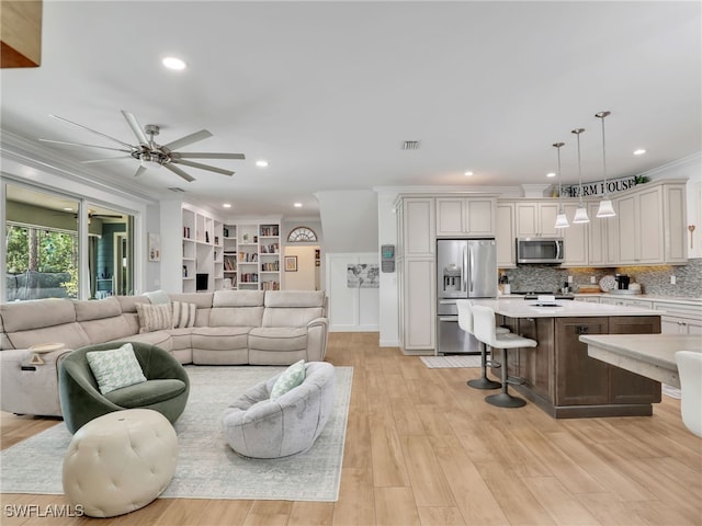 living area with ceiling fan, visible vents, crown molding, light wood-style floors, and recessed lighting