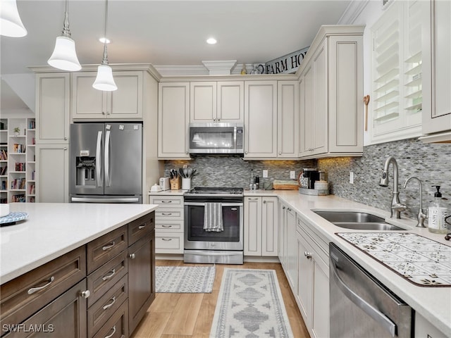 kitchen with dark brown cabinetry, light wood-style floors, light countertops, a sink, and appliances with stainless steel finishes