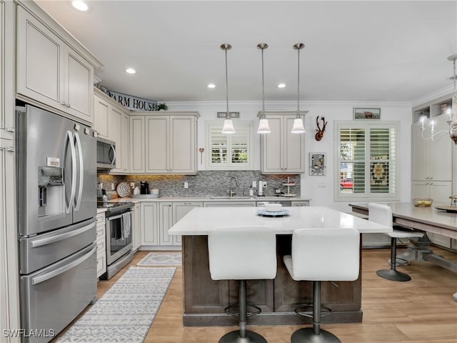 kitchen with a sink, light countertops, backsplash, and stainless steel appliances