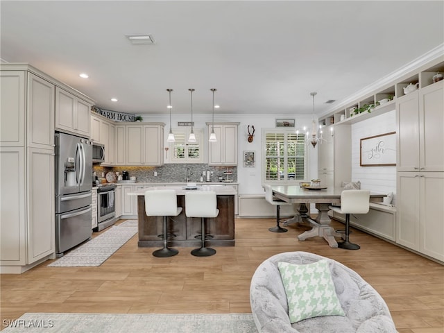 kitchen with a kitchen island, a breakfast bar, light countertops, backsplash, and stainless steel appliances
