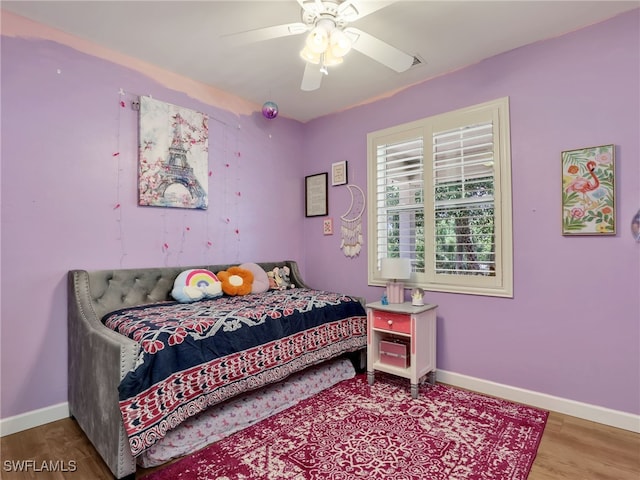 bedroom with baseboards, ceiling fan, and wood finished floors