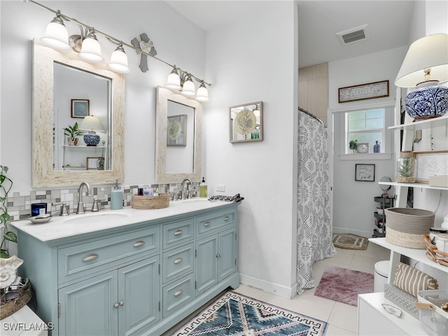 bathroom with tile patterned flooring, a sink, double vanity, and tasteful backsplash