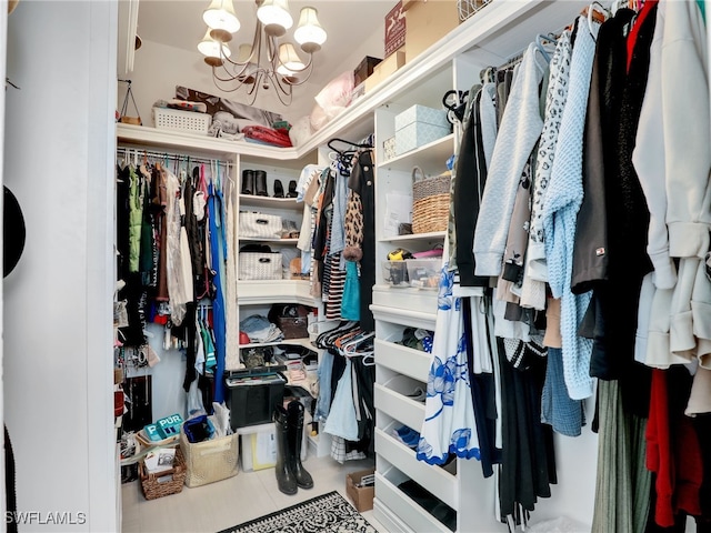 walk in closet featuring a notable chandelier
