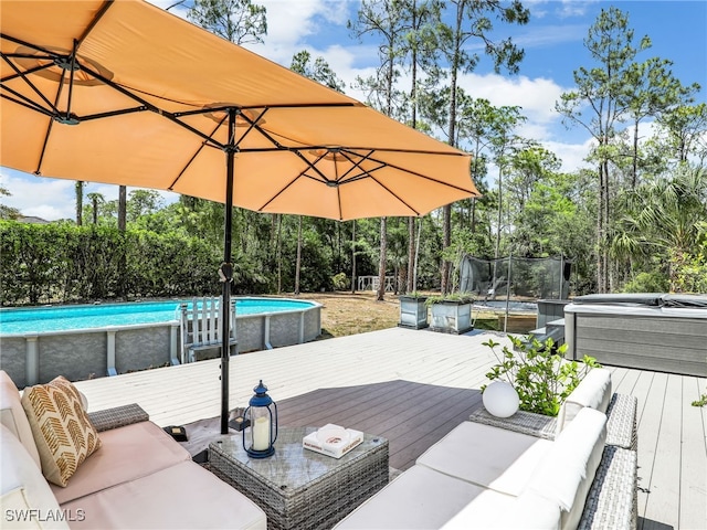 wooden deck featuring an outdoor living space, a trampoline, and an outdoor pool