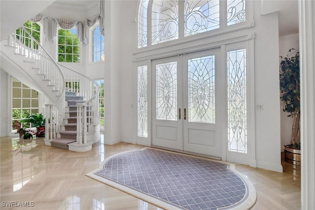 13488 Rosewood Ln, Naples, FL 34119 - foyer entrance featuring a towering ceiling, baseboards, stairs, and french doors