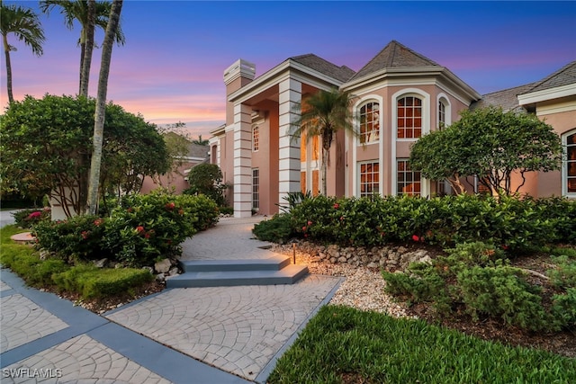 13488 Rosewood Ln, Naples, FL 34119 - view of front of house with stucco siding and a chimney
