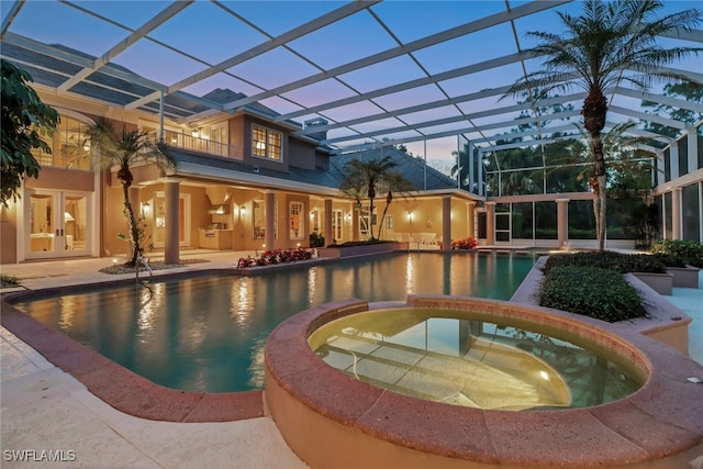 13488 Rosewood Ln, Naples, FL 34119 - pool at dusk with french doors, a pool with connected hot tub, a patio, and glass enclosure