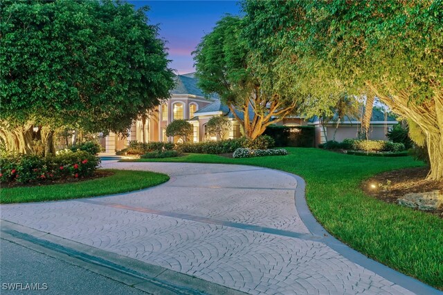 13488 Rosewood Ln, Naples, FL 34119 - view of front of house with curved driveway and a yard