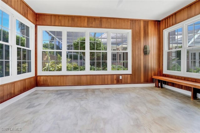 13488 Rosewood Ln, Naples, FL 34119 - unfurnished sunroom with wooden walls, concrete flooring, and healthy amount of natural light