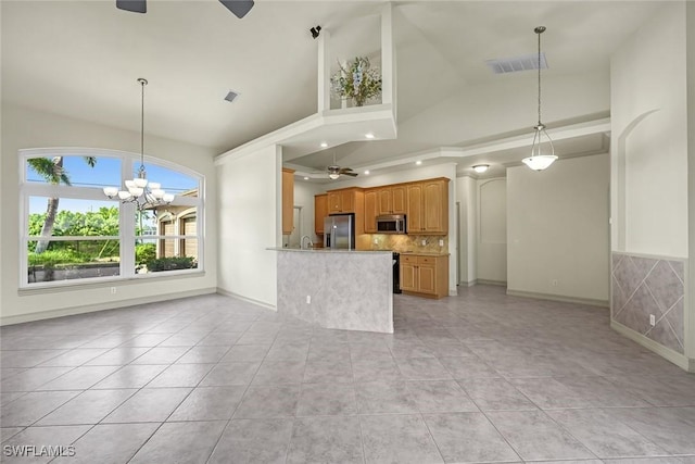 unfurnished living room with a ceiling fan, light tile patterned floors, a chandelier, baseboards, and high vaulted ceiling
