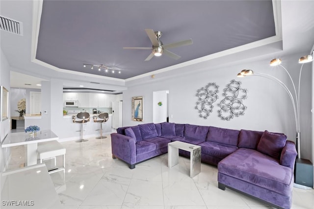 living area featuring a ceiling fan, visible vents, marble finish floor, and a raised ceiling
