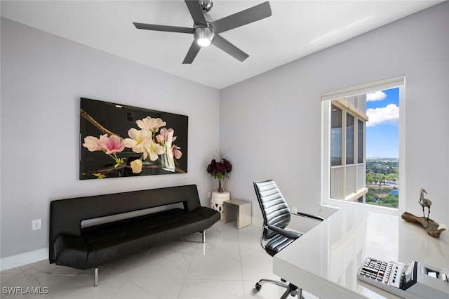 office space with baseboards, a ceiling fan, and marble finish floor