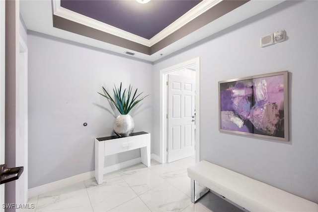 entrance foyer featuring marble finish floor, visible vents, crown molding, a tray ceiling, and baseboards