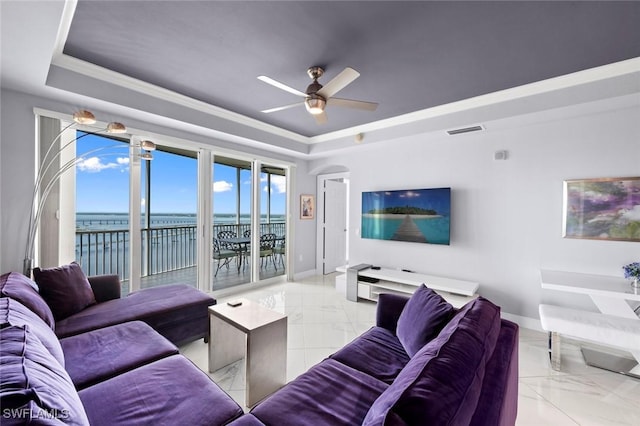 living room featuring marble finish floor, visible vents, ceiling fan, a raised ceiling, and baseboards