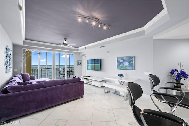 living area featuring a tray ceiling, marble finish floor, a ceiling fan, and ornamental molding