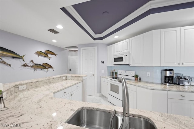 kitchen featuring white cabinets, visible vents, light stone counters, and white appliances