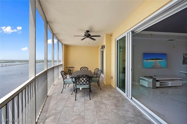 sunroom featuring outdoor dining space, a water view, visible vents, and ceiling fan