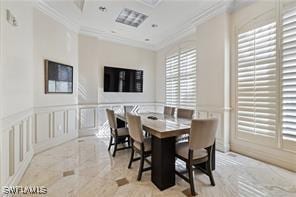 dining space with a decorative wall, wainscoting, and ornamental molding
