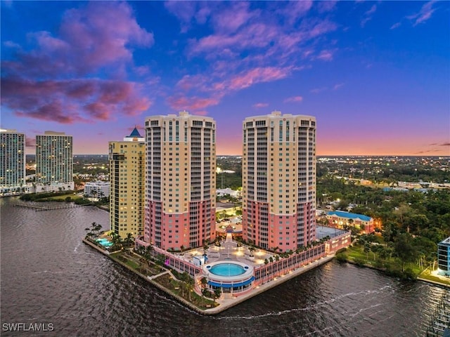 aerial view at dusk with a water view and a city view