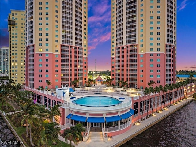 property at dusk featuring a water view and a view of city