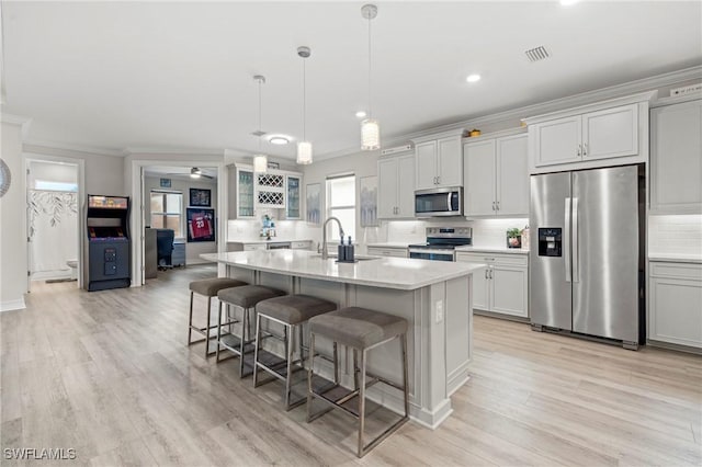 28140 Captiva Shell Loop, Bonita Springs, FL 34135 - kitchen featuring a breakfast bar area, a sink, appliances with stainless steel finishes, tasteful backsplash, and ornamental molding