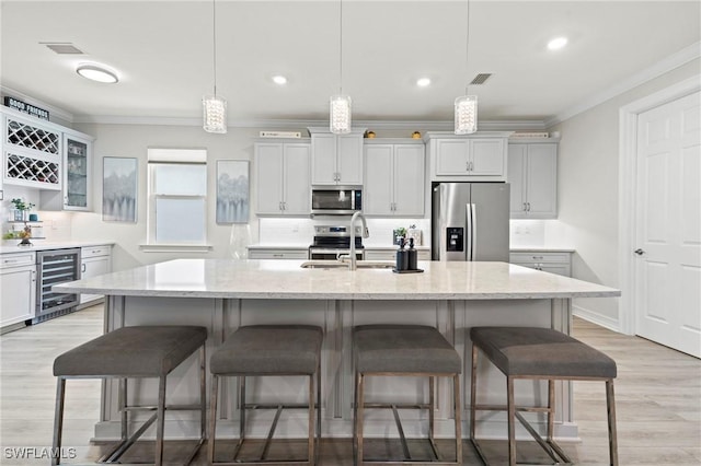 28140 Captiva Shell Loop, Bonita Springs, FL 34135 - kitchen featuring beverage cooler, ornamental molding, a sink, a kitchen breakfast bar, and appliances with stainless steel finishes