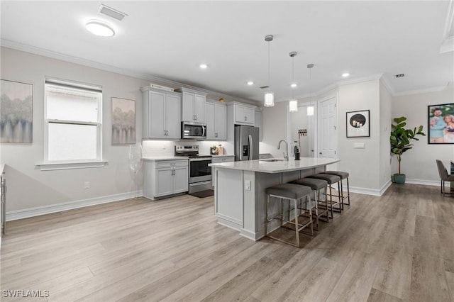 28140 Captiva Shell Loop, Bonita Springs, FL 34135 - kitchen featuring stainless steel appliances, ornamental molding, a breakfast bar area, light wood finished floors, and light countertops