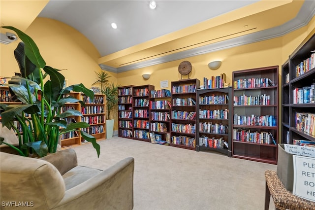living area featuring vaulted ceiling, bookshelves, and carpet floors