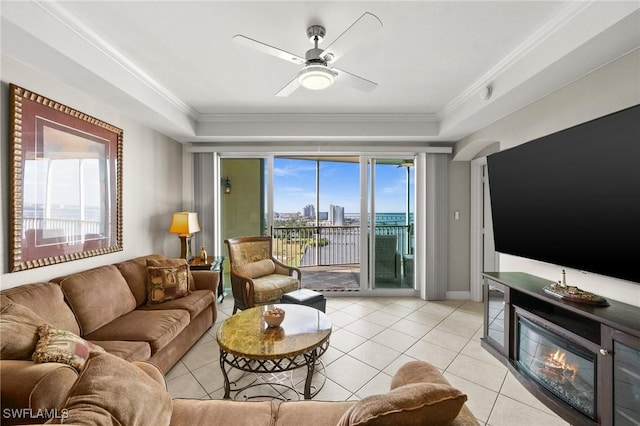 living area featuring ceiling fan, light tile patterned flooring, and ornamental molding