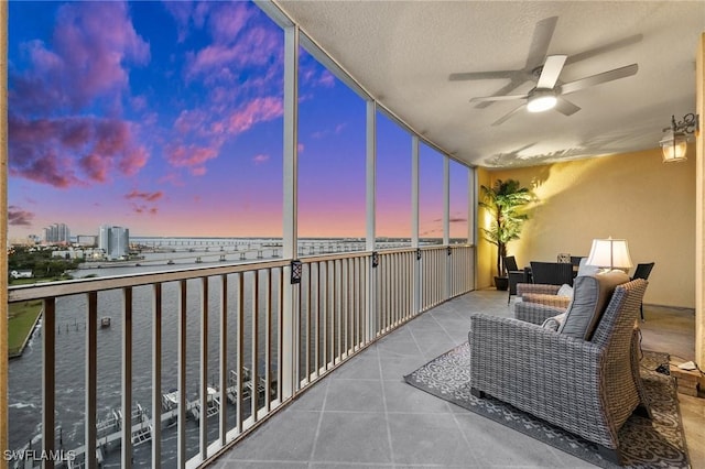 balcony with a water view and ceiling fan