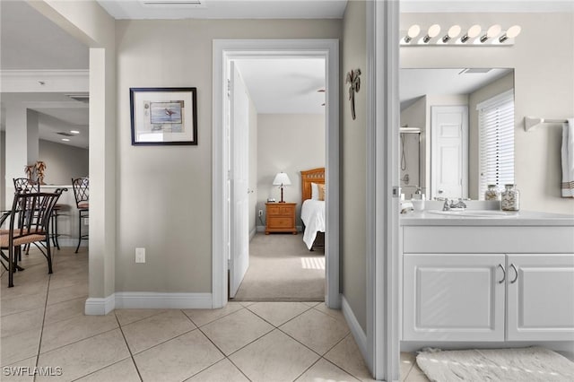 ensuite bathroom featuring tile patterned flooring, ensuite bathroom, baseboards, and vanity