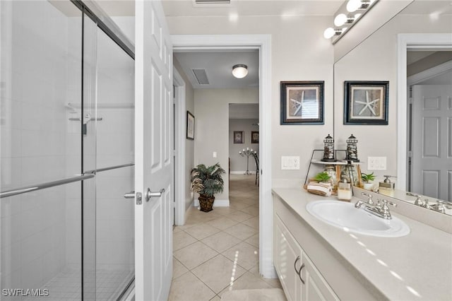 full bath with a stall shower, baseboards, visible vents, tile patterned flooring, and vanity