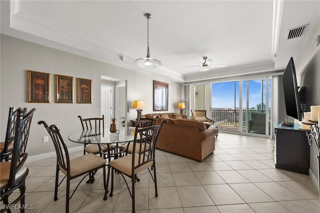dining room featuring light tile patterned floors, crown molding, visible vents, a raised ceiling, and ceiling fan