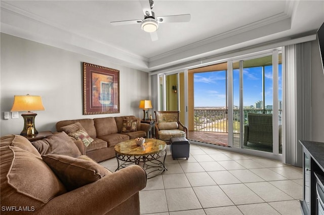 living area with a ceiling fan, ornamental molding, and light tile patterned floors