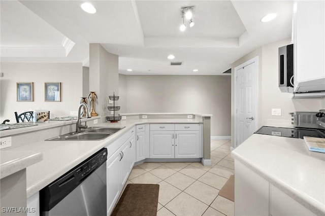 kitchen featuring a tray ceiling, a sink, white cabinets, and dishwasher