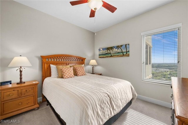 bedroom with light carpet, baseboards, and a ceiling fan