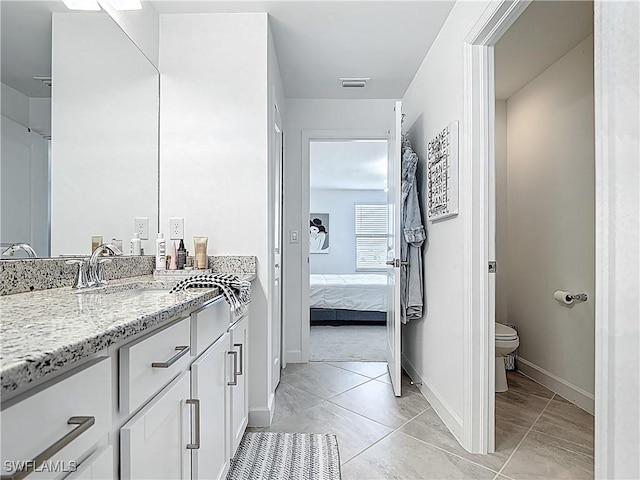 ensuite bathroom featuring vanity, ensuite bath, toilet, baseboards, and visible vents