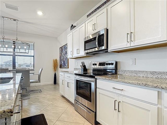 kitchen with visible vents, baseboards, white cabinets, light stone counters, and appliances with stainless steel finishes