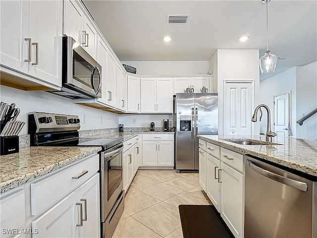 kitchen with a sink, appliances with stainless steel finishes, white cabinetry, and visible vents